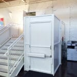 Symmetry Vertical Platform Lift in white with tall gate midmount operator installed by Arrow Lift