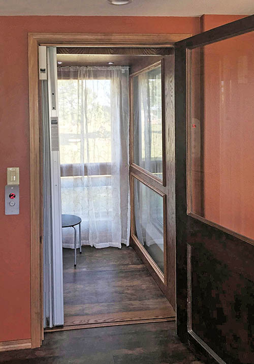 residential with windows covered by white curtains with coral walls