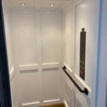 Symmetry Home Elevator with White Shaker Car Panel and round turn back handrail