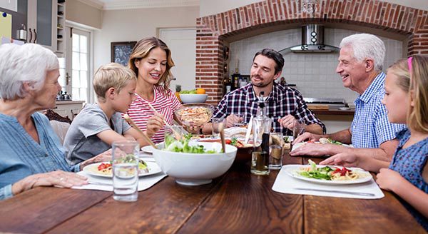 Family at dinner table eating happy